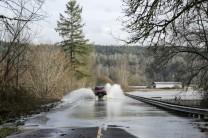 One person is dead and thousands are without power after storms caused severe flooding and evacuations across the Pacific Northwest.