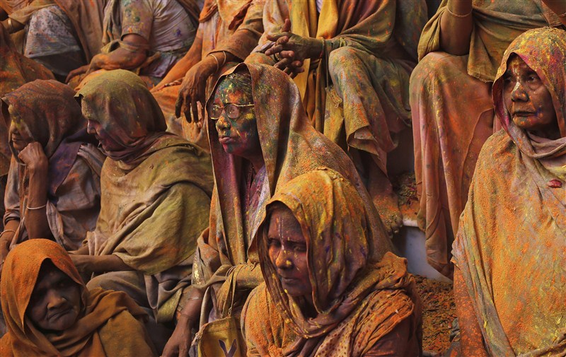 Widows daubed in colours take a break during the Holi celebrations organised by non-governmental organisation Sulabh International at a temple at Vrindavan, in the northern state of Uttar Pradesh. Holi festival,Holi,Holi celebrations,Indian widows celebrate Holi festival,widows celebrate Holi festival,Vrindavan temple,Sulabh International