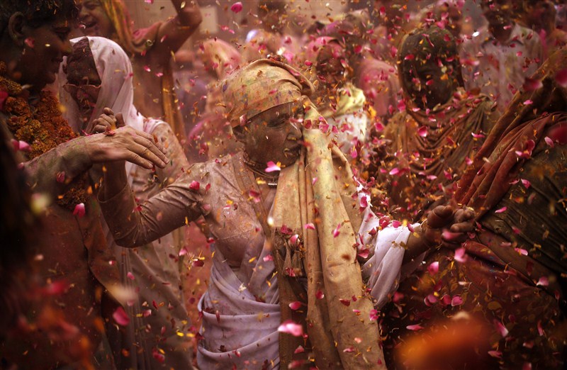 Widows daubed in colours take a break during the Holi celebrations organised by non-governmental organisation Sulabh International at a temple at Vrindavan, in the northern state of Uttar Pradesh. Holi festival,Holi,Holi celebrations,Indian widows celebrate Holi festival,widows celebrate Holi festival,Vrindavan temple,Sulabh International