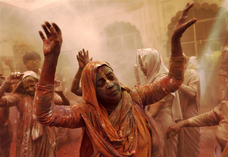 Widows daubed in colours take a break during the Holi celebrations organised by non-governmental organisation Sulabh International at a temple at Vrindavan, in the northern state of Uttar Pradesh. Holi festival,Holi,Holi celebrations,Indian widows celebrate Holi festival,widows celebrate Holi festival,Vrindavan temple,Sulabh International