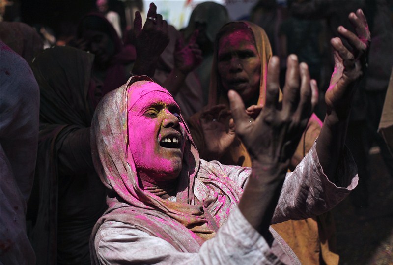 Widows daubed in colours take a break during the Holi celebrations organised by non-governmental organisation Sulabh International at a temple at Vrindavan, in the northern state of Uttar Pradesh. Holi festival,Holi,Holi celebrations,Indian widows celebrate Holi festival,widows celebrate Holi festival,Vrindavan temple,Sulabh International