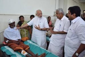 Narendra Modi,Narendra Modi visits Kerala,Narendra Modi visits Kerala temple tragedy site,Modi visits Kerala temple,Puttingal Devi temple,Peravur town,Chief Minister Oommen Chandy,Oommen Chandy,Kerala chief minister oommen chandy