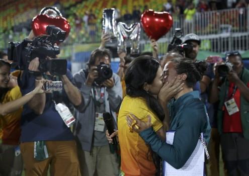 Rugby player Isadora Cerullo (BRA) of Brazil kisses Marjorie, a volunteer, after receiving her wedding proposal on the sidelines of the women's rugby medal ceremony.