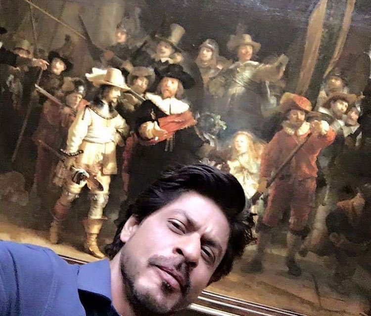 Bollywood superstar Shah Rukh Khan, who is currently in Amsterdam shooting for Imtiaz Alis film, gave his fans a glimpse of his date with the world famous Rijksmuseum. Shah Rukh Khan,Shah Rukh Khan selfi with Rijksmuseum,Rijksmuseum,Rijksmuseum painting,SRK poses with Rembrandt painting,Rembrandt painting