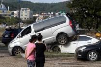 Women take a photograph of cars damaged by typhoon Chaba in Ulsan, South Korea.