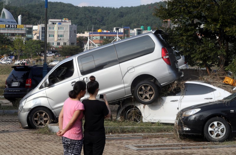 Women take a photograph of cars damaged by typhoon Chaba in Ulsan, South Korea. Typhoon Chaba,Typhoon Chaba batters South Korea,Typhoon Chaba hits South Korea,heavy rain in South Korea,flooding in South Korea,Typhoon Chaba batters South Korea and heads to Japan,Typhoon Chaba photos,Typhoon Chaba pics,Typhoon Chaba images,Typhoon Chab