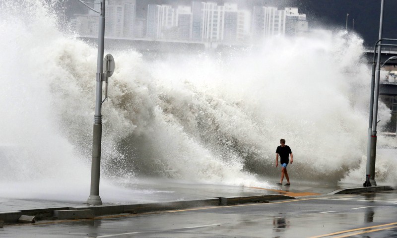 A man walks as a wave caused by typhoon Chaba splashes a seawall in Busan, South Korea. Typhoon Chaba,Typhoon Chaba batters South Korea,Typhoon Chaba hits South Korea,heavy rain in South Korea,flooding in South Korea,Typhoon Chaba batters South Korea and heads to Japan,Typhoon Chaba photos,Typhoon Chaba pics,Typhoon Chaba images,Typhoon Chab