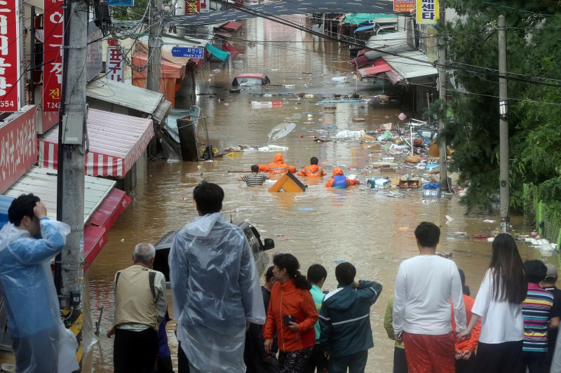 A road is submerged in flood waters caused by typhoon Chaba as residents look on in Ulsan, South Korea. Typhoon Chaba,Typhoon Chaba batters South Korea,Typhoon Chaba hits South Korea,heavy rain in South Korea,flooding in South Korea,Typhoon Chaba batters South Korea and heads to Japan,Typhoon Chaba photos,Typhoon Chaba pics,Typhoon Chaba images,Typhoon Chab