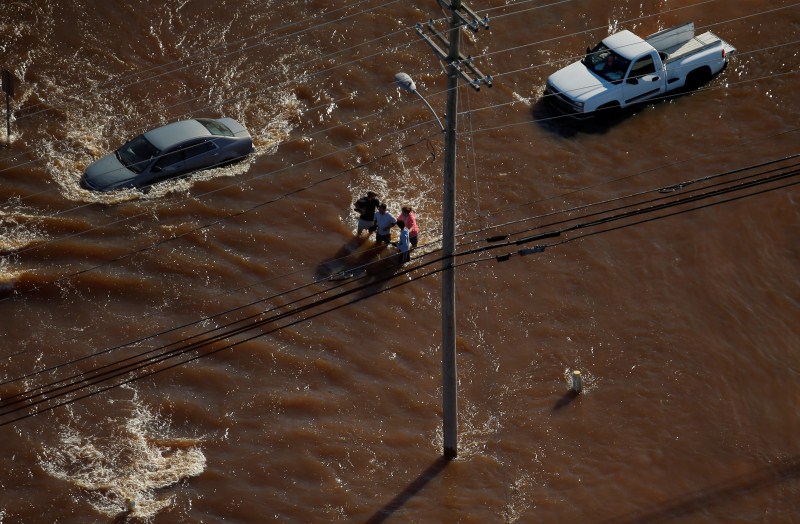 A group of people are seen walking through flood waters after Hurricane Matthew in Lumberton, North Carolina. Hurricane Matthew,North Carolina from above,North Carolina from above after Hurricane Matthew,after Hurricane Matthew,Hurricane Matthew shocking aerial photos,Hurricane Matthew shocking aerial pics,Hurricane Matthew shocking aerial images,Hurricane Matthe