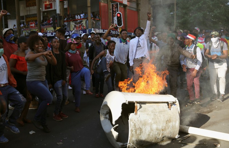 Students demanding free education chant slogans in front of burning barricade outside the University of the Witwatersrand at Braamfontein, in Johannesburg, South Africa. Student protests,Student protests in South Africa,university education,Students demanding free education,Johannesburg University