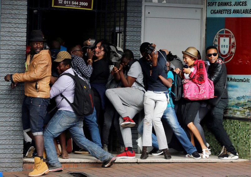 Students demanding free education react as they are fired at by riot police officers during a protest outside the University of the Witwatersrand at Braamfontein, in Johannesburg, South Africa. Student protests,Student protests in South Africa,university education,Students demanding free education,Johannesburg University