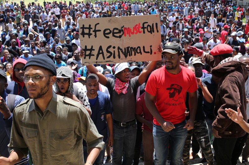 A demonstrator holds a placard during student protests demanding free education at the Johannesburg's University of the Witwatersrand, South Africa. Student protests,Student protests in South Africa,university education,Students demanding free education,Johannesburg University