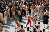 Men participate in self flagellation during the Shi'ite Muharram procession in Peshawar, Pakistan.