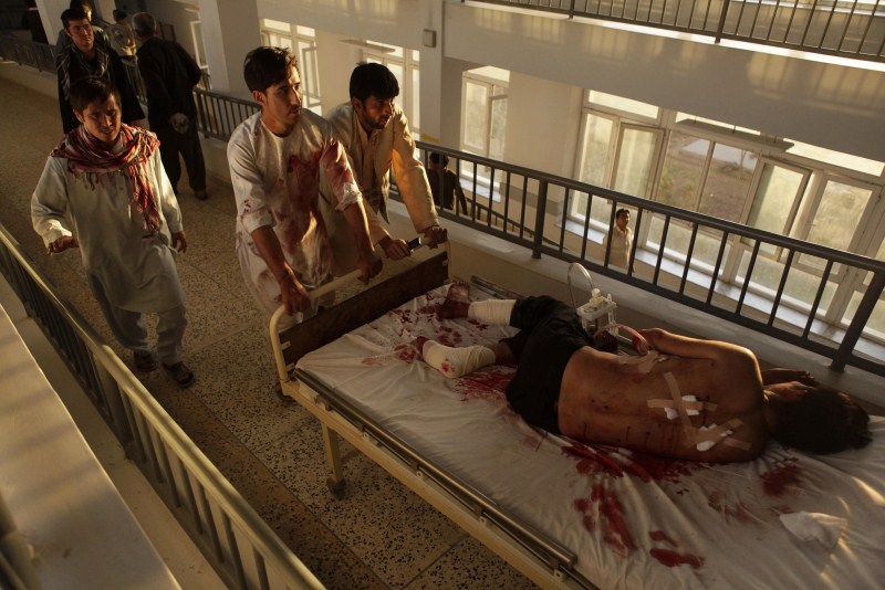 Afghan men carry a wounded man at a hospital after a bomb blast in northern Mazar-i-Sharif, Afghanistan. On Wednesday afternoon, an explosion outside a mosque in northern Afghanistan killed at least 14 people and wounded 24 at a similar gathering. There was no immediate claim of responsibility for that assault. Attacks on Afghan mosques,Afghan mosques,Attacks on mosques,Shi'ite Muslims,Ashura,Mazar-i-Sharif,Bomb Blast mosque,Bomb Blast,mosque Bomb Blast