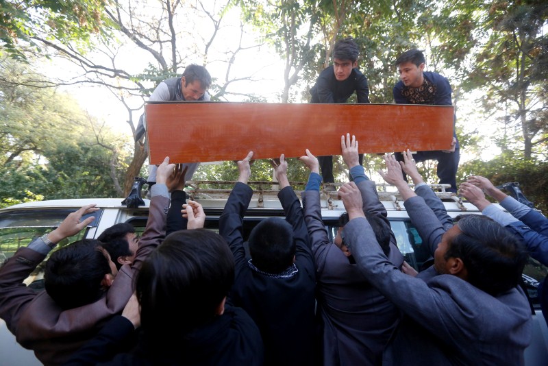 Afghan men transfer a coffin of the civilian on top of a bus at a hospital in Kabul, Afghanistan. Attacks on Afghan mosques,Afghan mosques,Attacks on mosques,Shi'ite Muslims,Ashura,Mazar-i-Sharif,Bomb Blast mosque,Bomb Blast,mosque Bomb Blast