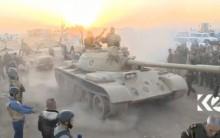 Tanks move past soldiers in military fatigues as the sun begins to set east of Mosul, where the Iraqi government launched a U.S.-backed offensive to drive Islamic State from the northern city, in this still image taken from video released October 17, 2016.