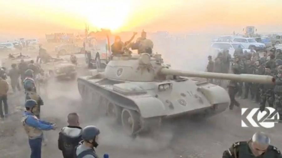 Tanks move past soldiers in military fatigues as the sun begins to set east of Mosul, where the Iraqi government launched a U.S.-backed offensive to drive Islamic State from the northern city, in this still image taken from video released October 17, 2016. Battle for Mosul begins,Battle for Mosul,Islamic State,Iraqi forces,Iraqi city,IS begins,Mosul,Mosul Battle,gunfire and car bombs,Iraqi attack on Mosul begins