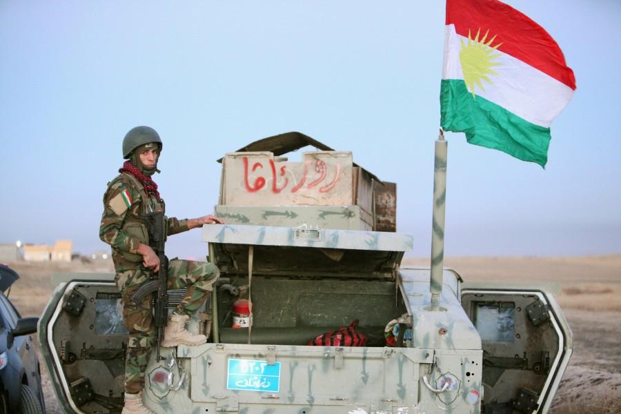 A member of Peshmerga forces stands on a military vehicle in the east of Mosul. Battle for Mosul begins,Battle for Mosul,Islamic State,Iraqi forces,Iraqi city,IS begins,Mosul,Mosul Battle,gunfire and car bombs,Iraqi attack on Mosul begins