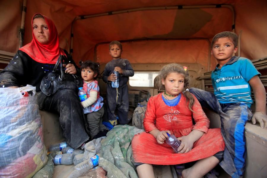Displaced people who are fleeing from clashes sit at a military vehicle in Qayyarah, during an operation to attack Islamic State militants in Mosul, Iraq. Mosul,Iraqi forces,Islamic State,assault on Mosul,Mosul offensive,Mosul civilians,Fleeing Mosul,Assault on ISIS in Mosul,Assault on ISIS,ISIS