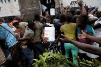 People fight for a bucket of supplies during a distribution after Hurricane Matthew in Torbeck, Haiti.
