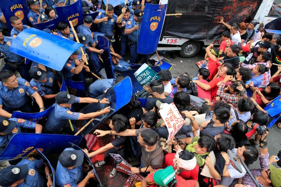 Various activist and Indigenous People's (IP) groups clash with anti-riot policemen during a protest against the continuing presence of U.S. troops in the Philippines in front of the U.S. Embassy in metro Manila. Anti-U.S. protest,Anti-U.S. protest in Philippines,Philippine police,U.S. embassy,Manila,Philippines turns violent