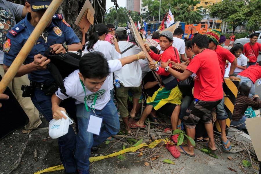 A police officer tries to detain a demonstrator after a violent dispersal of various activist and Indigenous People's (IP) groups protesting against the continuing presence of U.S. troops in the Philippines in front of the U.S. Embassy in metro Manila. Anti-U.S. protest,Anti-U.S. protest in Philippines,Philippine police,U.S. embassy,Manila,Philippines turns violent