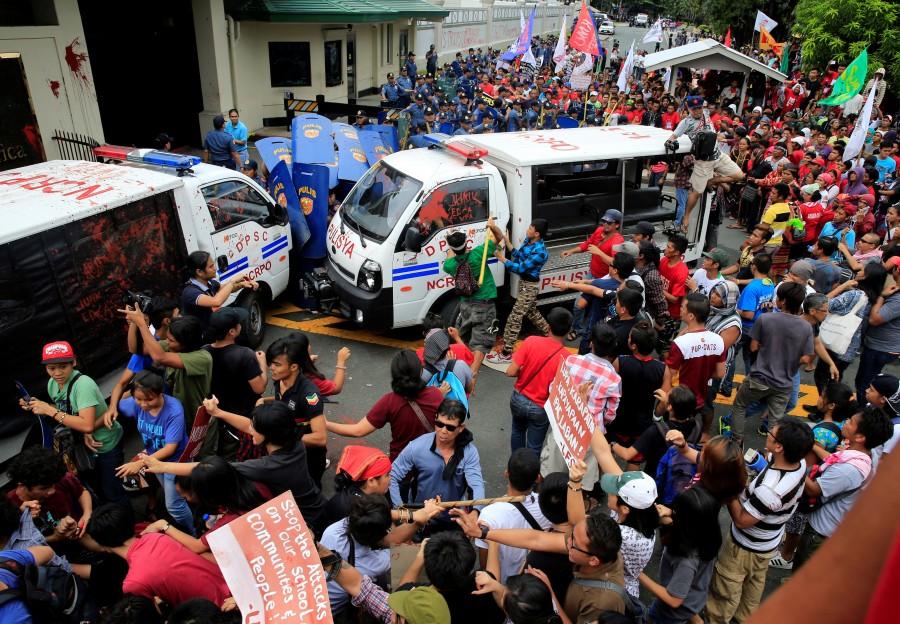 Protesters try to trash a police mobile patrol vehicle as they join various activist and Indigenous People's (IP) groups in a protest against the continuing presence of U.S. troops in the Philippines in front of the U.S. Embassy in metro Manila. Anti-U.S. protest,Anti-U.S. protest in Philippines,Philippine police,U.S. embassy,Manila,Philippines turns violent