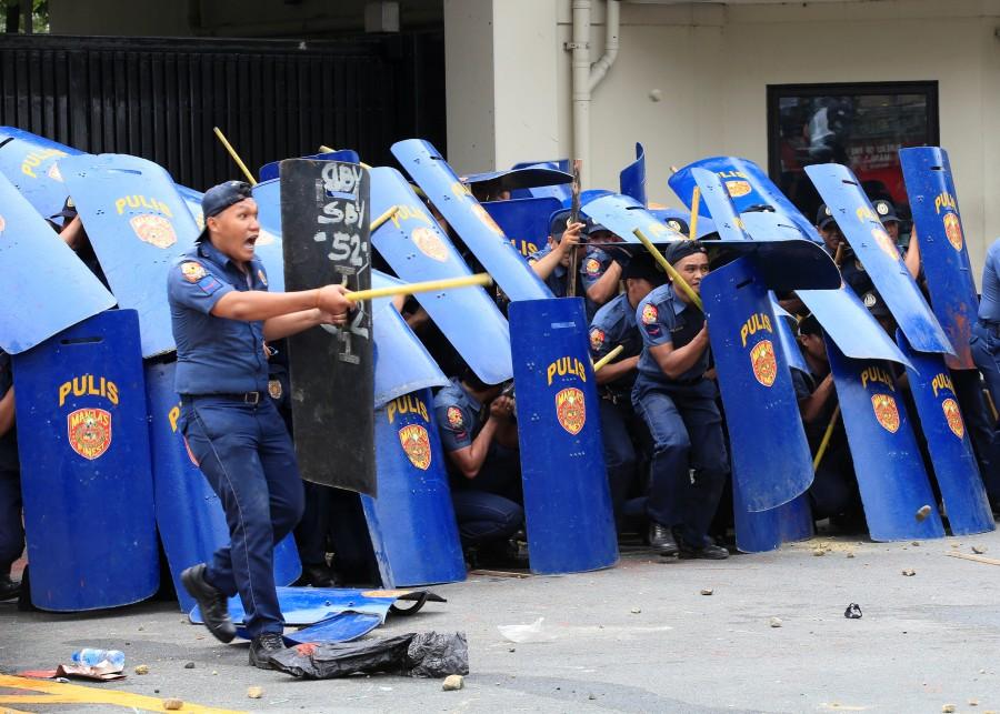 Policemen advance in formation during a violent dispersal of various activist and Indigenous People's (IP) groups protesting against the continuing presence of U.S. troops in the Philippines in front of the U.S. Embassy in metro Manila. Anti-U.S. protest,Anti-U.S. protest in Philippines,Philippine police,U.S. embassy,Manila,Philippines turns violent