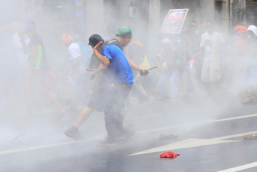 Demonstrators try to evade a water canon after a violent dispersal of various activist and Indigenous People's (IP) groups protesting against the continuing presence of U.S. troops in the Philippines in front of the U.S. Embassy in metro Manila. Anti-U.S. protest,Anti-U.S. protest in Philippines,Philippine police,U.S. embassy,Manila,Philippines turns violent