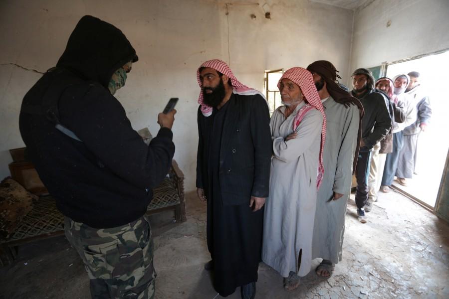 Iraqi refugees that fled violence in Mosul get inspected from rebel fighters upon arrival in al-Kherbeh village, northern Aleppo province, Syria. Iraqis,Islamic State,Mosul,Fleeing one war-torn country to another,refugees,Iraq refugees,Syria,northeastern Syria,Iraqi refugees