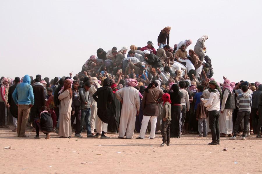 Iraqi refugees that fled violence in Mosul and internally displaced Syrians who fled Islamic State controlled areas in Deir al-Zor, buy food and water near the Iraqi border, in Hasaka Governorate. Iraqis,Islamic State,Mosul,Fleeing one war-torn country to another,refugees,Iraq refugees,Syria,northeastern Syria,Iraqi refugees