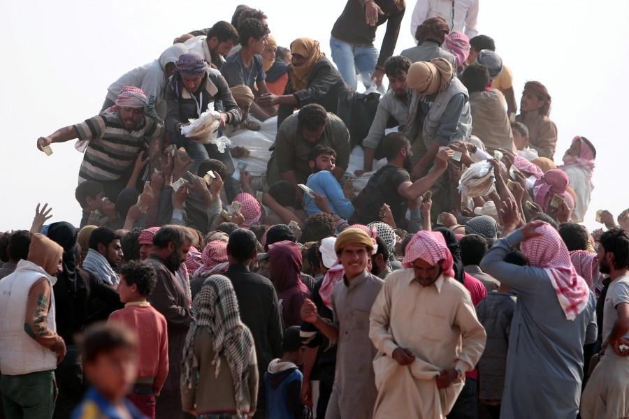Iraqi refugees that fled violence in Mosul and internally displaced Syrians who fled Islamic State controlled areas in Deir al-Zor, buy food and water near the Iraqi border, in Hasaka Governorate. Iraqis,Islamic State,Mosul,Fleeing one war-torn country to another,refugees,Iraq refugees,Syria,northeastern Syria,Iraqi refugees