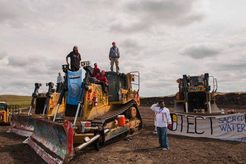 Protesters stand on heavy machinery after halting work on the Energy Transfer Partners Dakota Access oil pipeline near the Standing Rock Sioux reservation near Cannon Ball, North Dakota. North Dakota pipeline protest,pipeline protest,North Dakota protest,violent clashes,Dakota Access oil pipeline project,Dakota oil pipeline project,Native American