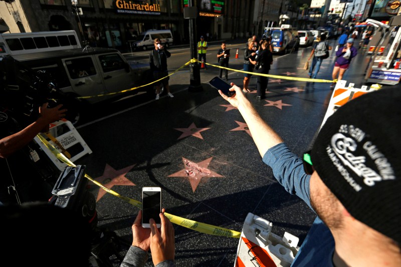 People take photos of Donald Trump's star on the Hollywood Walk of Fame after it was vandalized. Los Angeles police expect to arrest someone for the vandalism, which left Trump's name scratched out of the star, the emblem in the middle dislodged and chips missing. Donald Trump,Trump's Hollywood star vandalized,Hollywood Walk of Fame,Donald Trump star vandalized,sledgehammer,Hillary Clinton