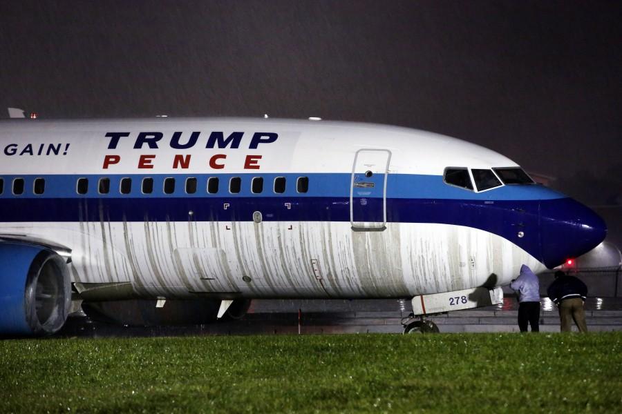 Men inspect a campaign plane that had been carrying U.S. Republican vice presidential candidate Mike Pence after it skidded off the runway while landing in the rain at LaGuardia Airport in New York, U.S. Mike Pence skids,Mike Pence,Mike Pence skids off runway,Mike Pence off runway,LaGuardia Airport,LaGuardia airport