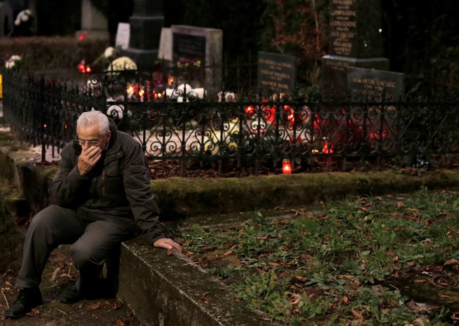 A man is seen nearby a grave at Mirogoj cemetery in Zagreb. All Saints' Day celebrations,All Saints Day,All Saints Day 2016,All Saints' Day 2016,All Saints' Day quotes,All Saints' Day wishes,All Saints' Day greetings,All Souls' day