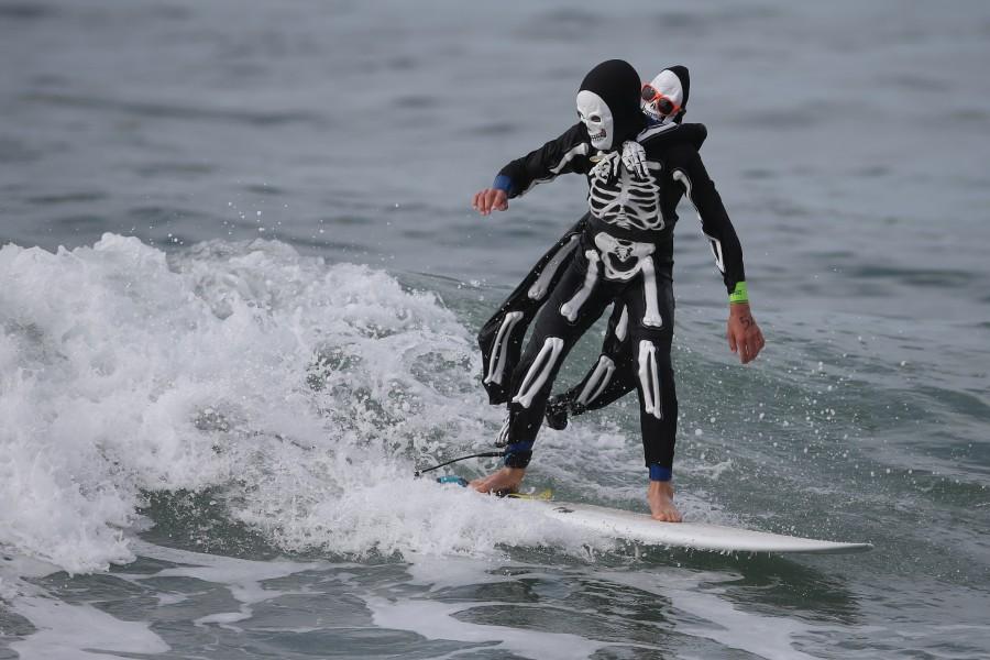 A man dressed as a skeleton competes in the Haunted Heats Halloween Surf Contest in Santa Monica, California. Halloween surf contest,Halloween surf contest 2016,Halloween meets surfing,Santa Monica,Haunted Heats Halloween Surf Contest