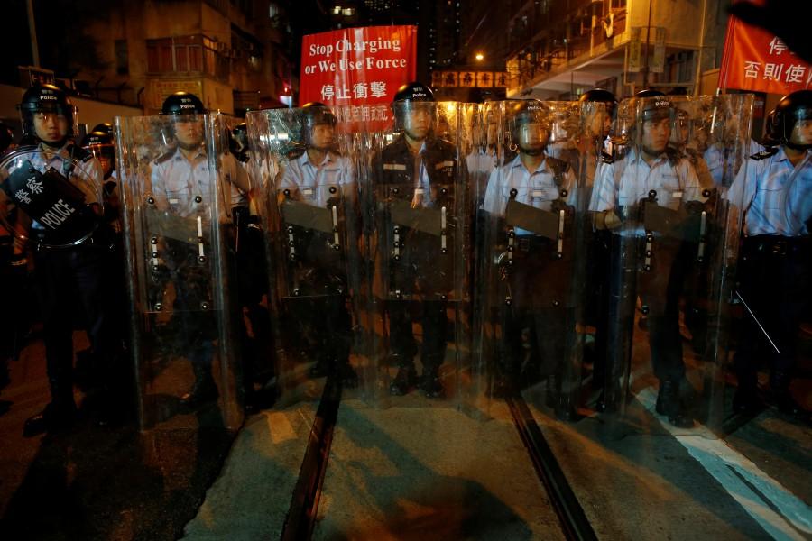 Riot police stand on a tram track during a standoff with protesters outside China Liaison Office in Hong Kong. Anti-China march,Anti-China march in Hong Kong,China,China parliament,Beijing,Hong Kong pro-independence