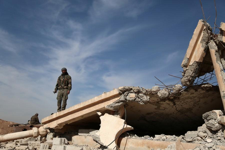 An Syrian Democratic Forces (SDF) fighter stands with his weapon on the rubble of a destroyed building, north of Raqqa city, Syria November 7, 2016. U.S-backed Syrian armed groups have captured a number of villages in the first days of an offensive to retake the city of Raqqa from Islamic State militants, a war monitor and a Kurdish source said on Monday. U.S-backed Syrian,U.S,Islamic State,Raqqa,Islamic State militants
