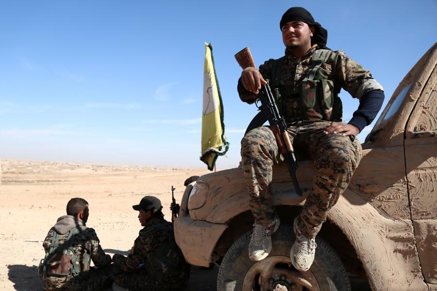A Syrian Democratic Forces (SDF) fighter rests with his weapon on a vehicle camouflaged with mud, north of Raqqa city, Syria. U.S-backed Syrian,U.S,Islamic State,Raqqa,Islamic State militants
