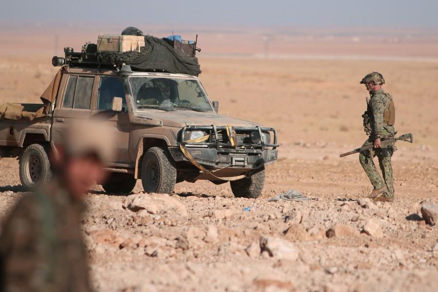 A U.S. fighter walks with his weapon near a military vehicle, north of Raqqa city, Syria. U.S-backed Syrian,U.S,Islamic State,Raqqa,Islamic State militants