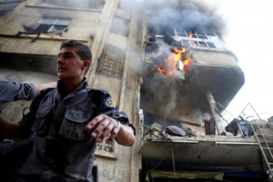 Civil defence members work at a site hit by an airstrike in the rebel-held Douma neighbourhood of Damascus, Syria. Air strikes,Air strikes in Damascus,Damascus,Syrian army edges closer,Syrian army,Syrian Army tightens,Civil defence members,Syria