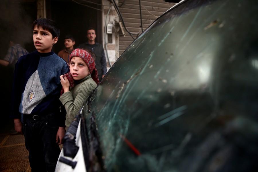 Boys stand at a site hit by an airstrike in the rebel-held Douma neighbourhood of Damascus, Syria. Air strikes,Air strikes in Damascus,Damascus,Syrian army edges closer,Syrian army,Syrian Army tightens,Civil defence members,Syria