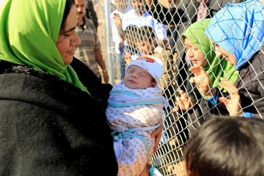 People see their relatives who had fled from Mosul at a fence surrounding Al-Khazer refugee camp, east of Mosul, Iraq.