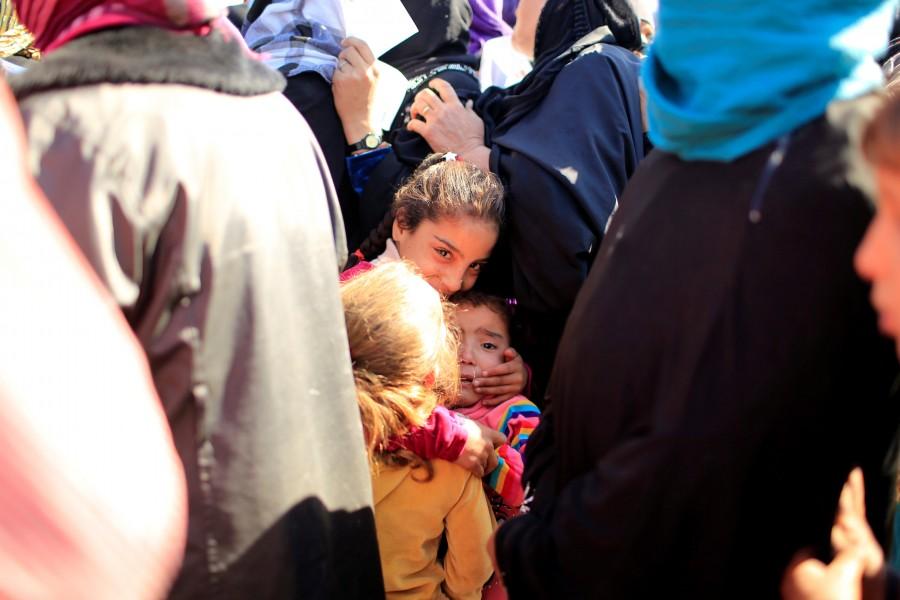 Displaced children who had fled from Mosul stand with their family in line to receive aid at Al-Khazer refugee camp, east of Mosul. Islamic State,Mosul,Mosul meet,Tearful reunions,Tearful reunions after escaping Islamic State,Mosul meet pics