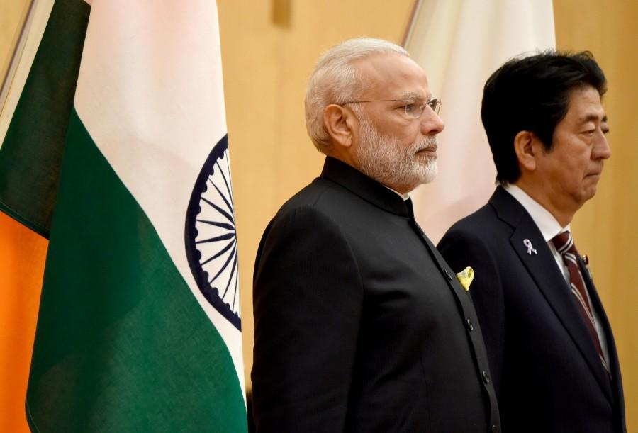Indian Prime Minister Narendra Modi (L) and his Japanese counterpart Shinzo Abe listen to national anthems when they review an honour guard before their meeting at Abe's official residence in Tokyo, Japan. Narendra Modi,Shinzo Abe,annual bilateral summit,India-Japan bilateral summit,India-Japan summit