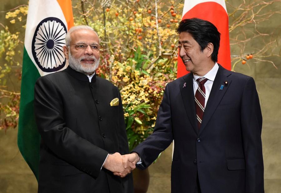 Indian Prime Minister Narendra Modi (L) is welcomed by his Japanese counterpart Shinzo Abe upon his arrival for their meeting at Abe's official residence in Tokyo, Japan. Narendra Modi,Shinzo Abe,annual bilateral summit,India-Japan bilateral summit,India-Japan summit