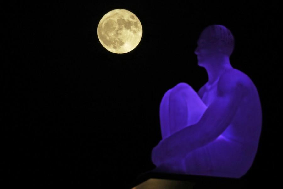The supermoon rises behind one of the seven statues by spanish artist Jaume Plensa on Massena square in Nice, France. Supermoon,Supermoon around world,Supermoon in india,Supermoon pics,Supermoon images,Supermoon stills,Supermoon pictures,Supermoon photos,Supermoon new pics