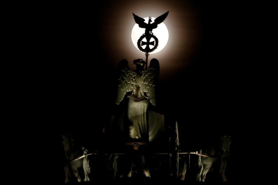 The rising moon is seen behind the Brandenburg Gate quadriga in Berlin, Germany. Supermoon,Supermoon around world,Supermoon in india,Supermoon pics,Supermoon images,Supermoon stills,Supermoon pictures,Supermoon photos,Supermoon new pics