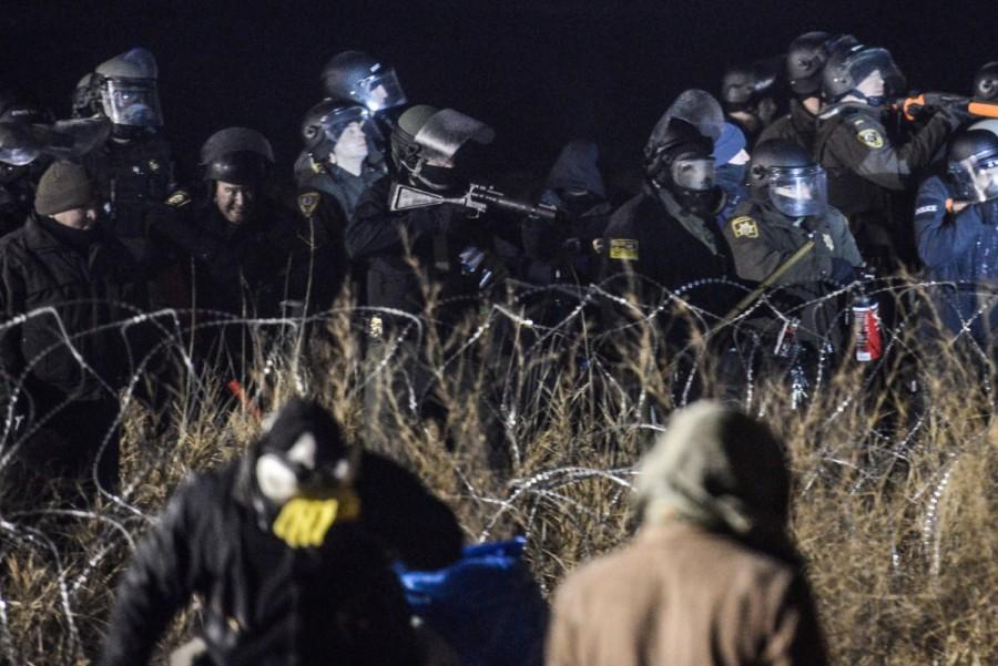 Police confront protesters with a rubber bullet gun during a protest against plans to pass the Dakota Access pipeline near the Standing Rock Indian Reservation, near Cannon Ball, North Dakota, U.S. November 20, 2016. North Dakota,North Dakota pipeline protest,Dakota Access oil pipeline project,Native American tribe,Native American